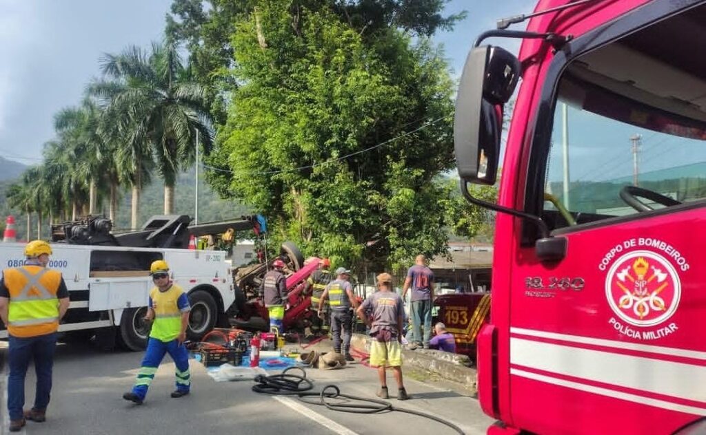 Caminhão com madeira tomba na Tamoios e deixa motorista de 38 anos preso às ferragens, em Caraguatatuba